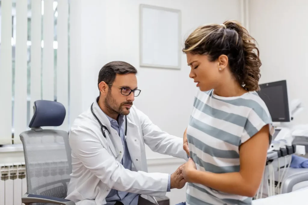 Médico examinando mulher em busca de tratamento complementar para cálculo renal.