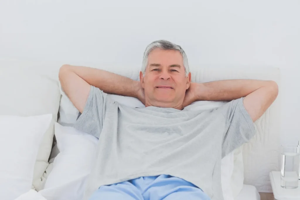 Imagem de um homem deitado tranquilo em sua cama durante a recuperação da vasectomia.